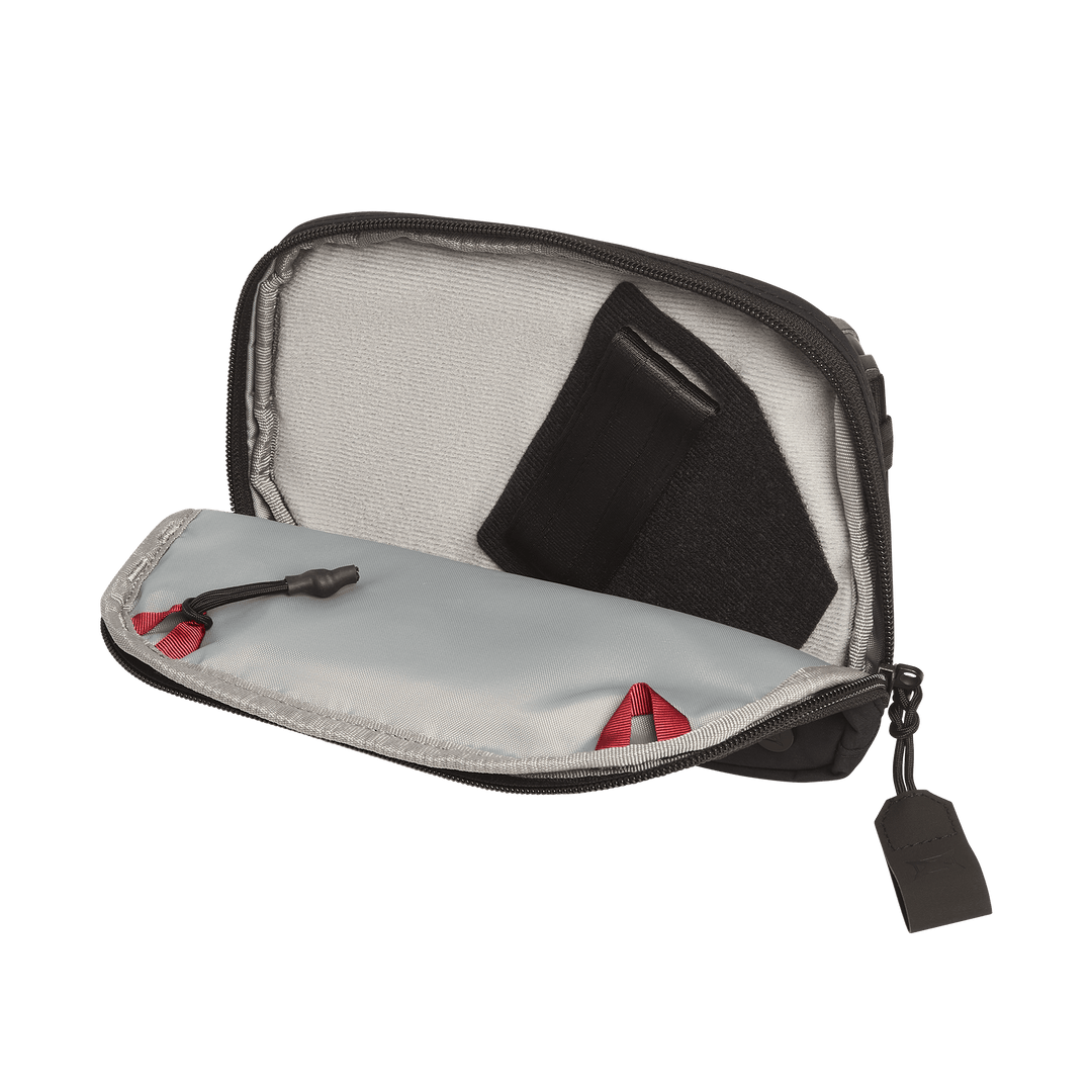 The Vertx Everyday Fanny Pack 2.1 is a compact EDC waist pack with a light gray interior, black zipper with red accent, and ballistic-panel compatibility. Shown open with a black fabric item stored inside.