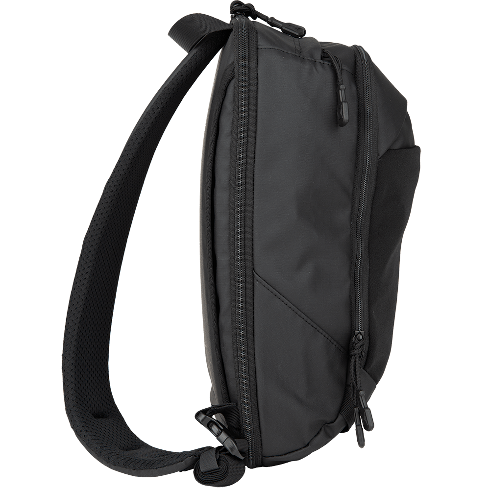 The Vertx Urban Ghost Sling, a sleek black bag by Vertx, is depicted in a side view. This sling bag combines compactness with ample storage space, boasting a padded adjustable strap and several zippers. Its design is tailored for everyday carry (EDC), with visible compartments and a discreet compartment specifically for secure concealed carry of essential items.