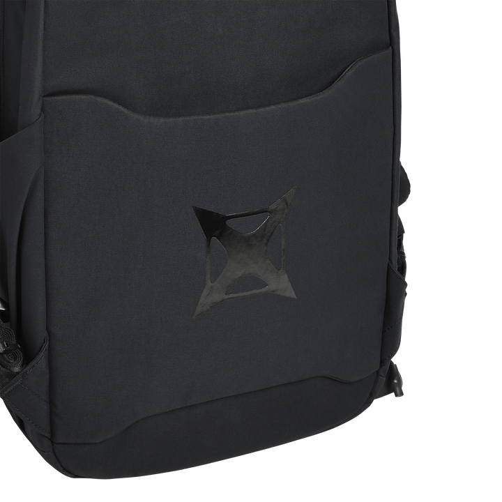 A close-up of the Vertx Any Day Backpack’s front pocket highlights its matte black geometric logo. The image shows part of the front and side of this ballistic-panel compatible EDC backpack by Vertx against a white background.