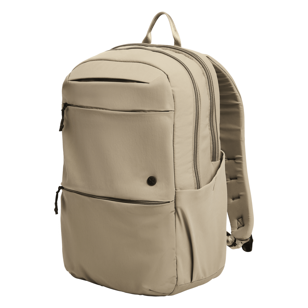The Vertx Any Day Backpack in Outpost Tan features two large zippered compartments, a front zippered pocket, two side pockets, top handle, and is ballistic-panel compatible. Shown against a plain white background.