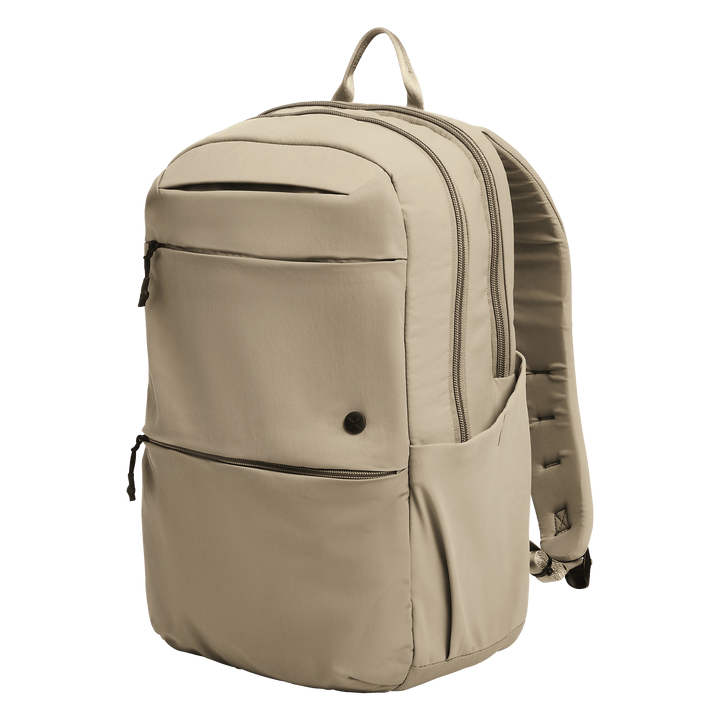The Vertx Any Day Backpack in Outpost Tan features two large zippered compartments, a front zippered pocket, two side pockets, top handle, and is ballistic-panel compatible. Shown against a plain white background.