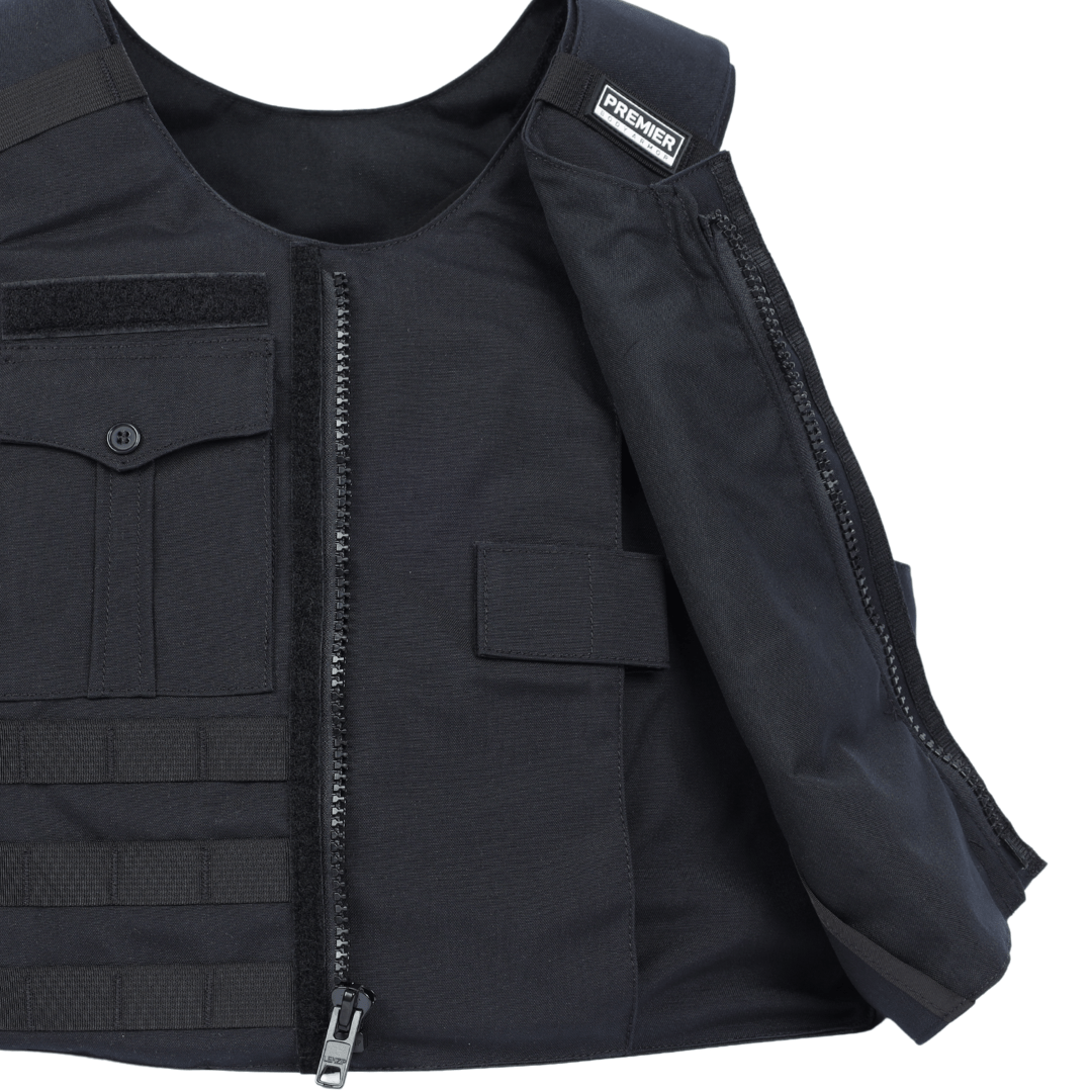 A close-up of the Premier Body Armor Patrol Bravo, a black Level IIIA soft armor patrol vest with a partially open front zipper, front pockets, and a "PREMIER" label on the shoulder, made from heavy-duty fabric.