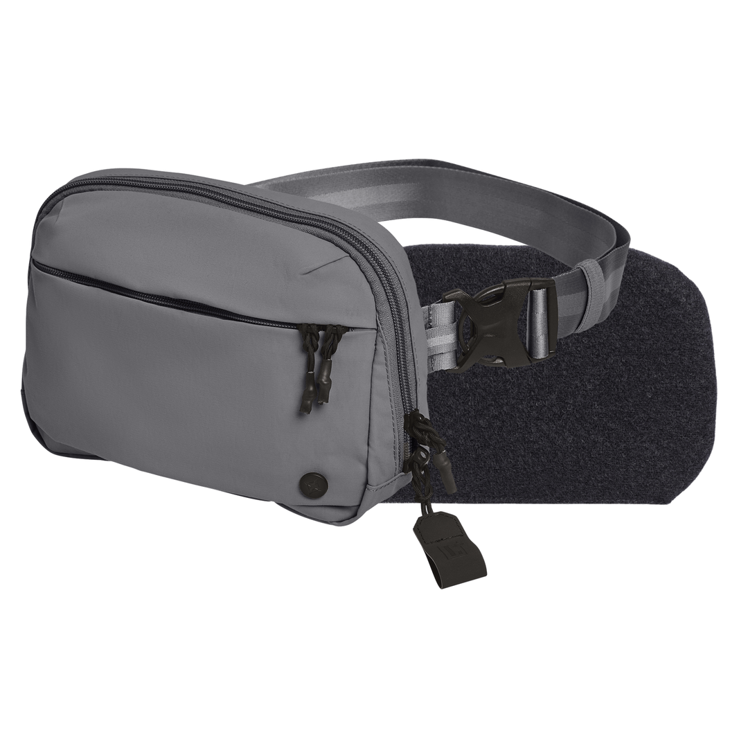The Armored Vertx Everyday Fanny Pack+ Bundle by Vertx/Premier is a gray CCW waist pack with two zippered compartments, a black adjustable strap, side-release buckle, and a small black lock on the front pocket’s zipper pulls for extra security.