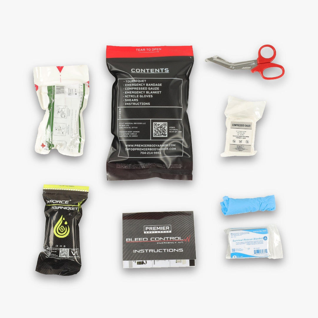 A flat lay image of the PBA Bleed Control Kit's contents, designed as a comprehensive solution under the STAT brand. Items include bandages, a pair of red-handled scissors, a S.T.A.T. Tourniquet, a pack of latex gloves, gauze, instructions, an emergency bandage, and a compressed bandage. All items are neatly organized on a white background.